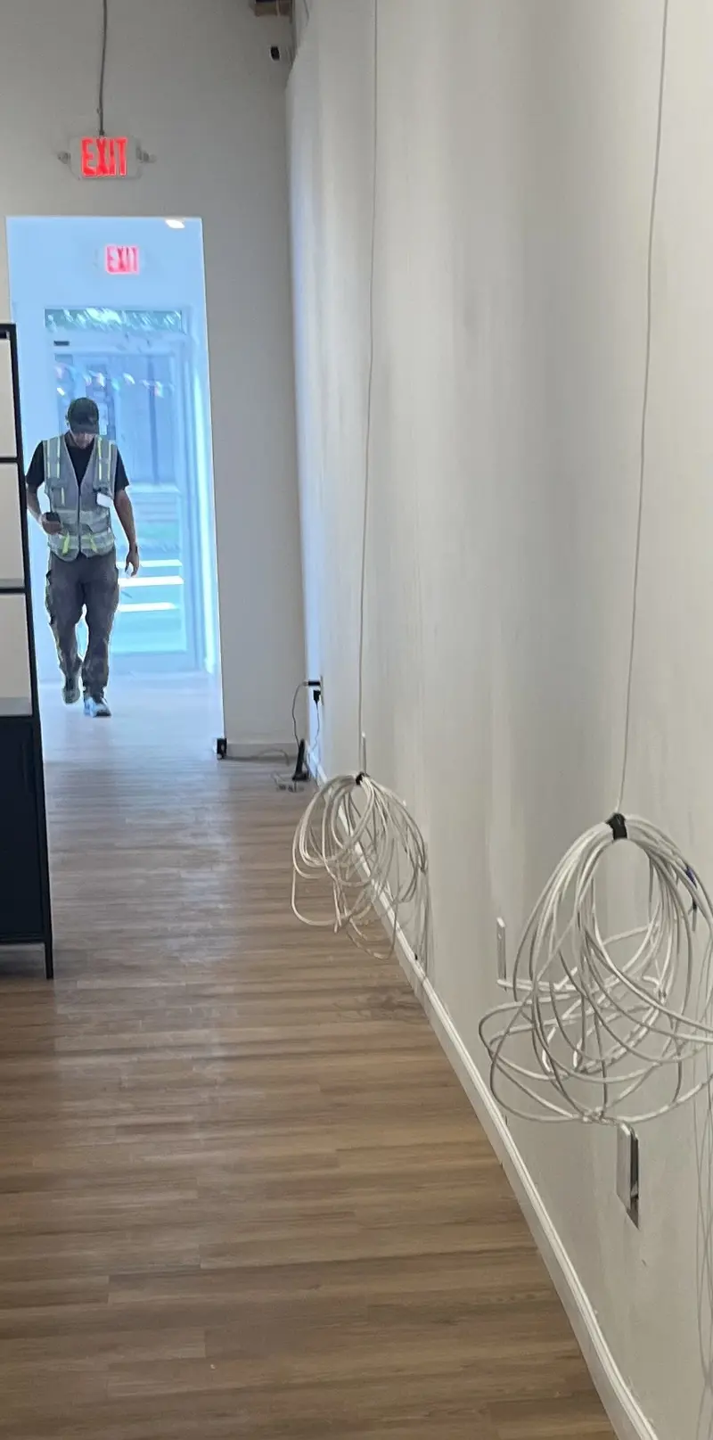 Technician in a commercial hallway with new low-voltage cable runs