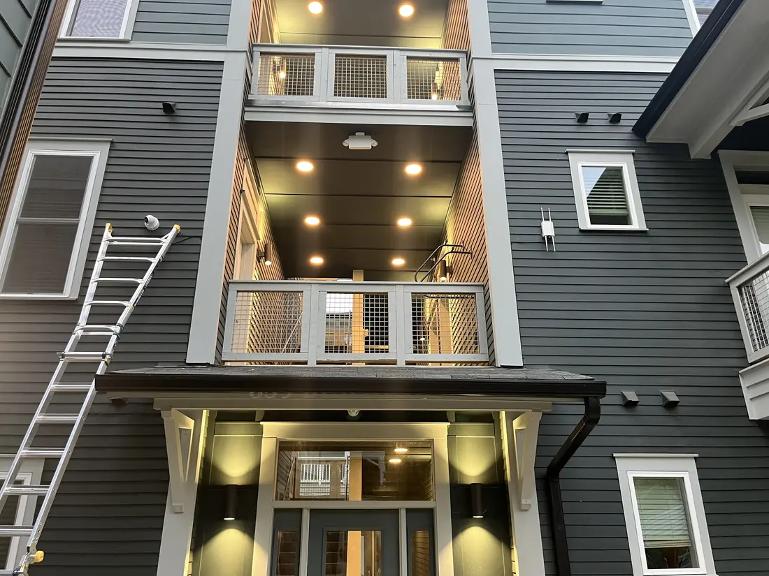 Cameras installed on a multi-story residential building, with the ladder still in place
